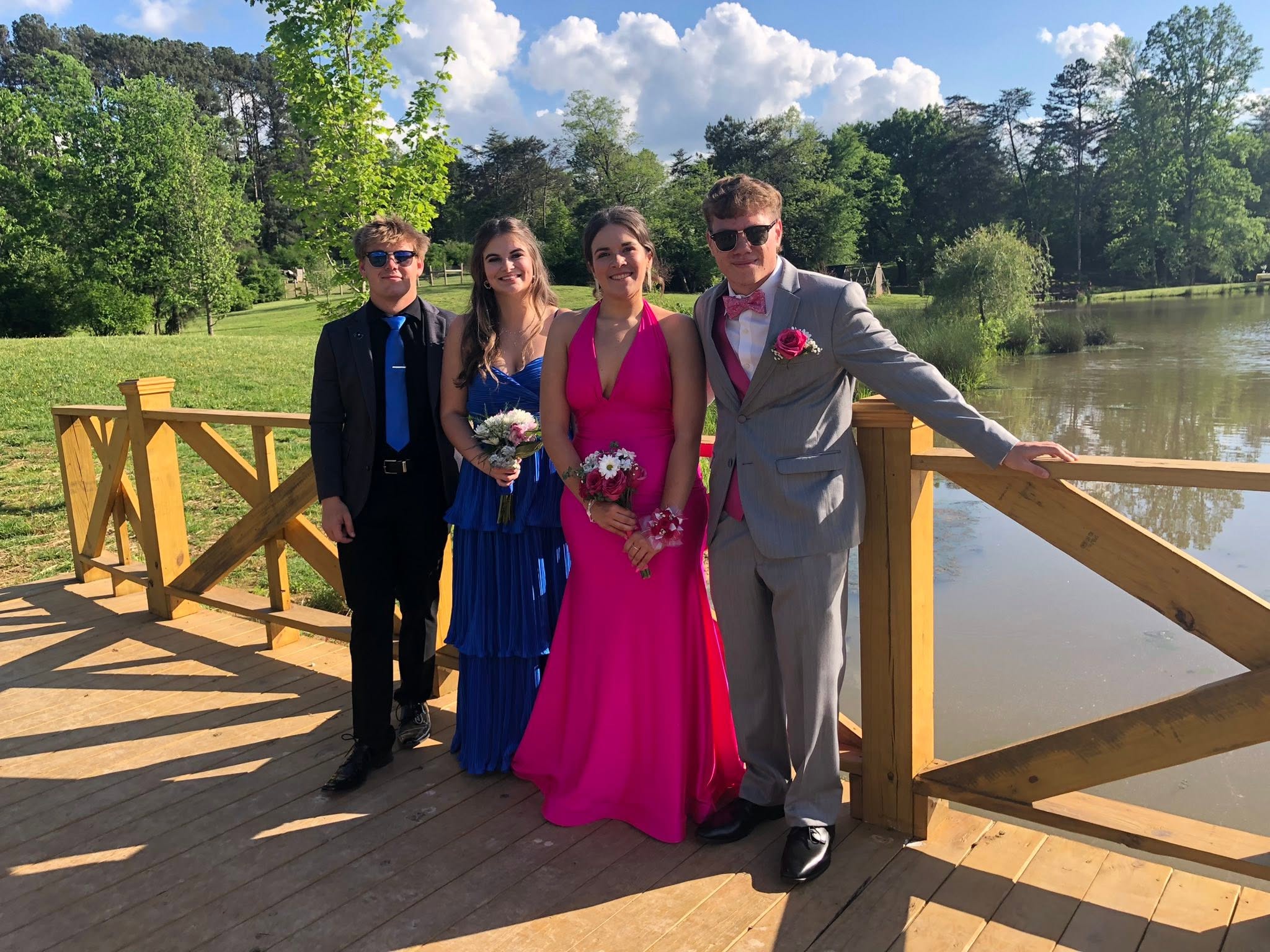 Friends posing on the pond bridge before prom